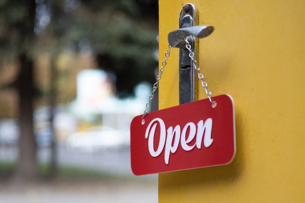 red-open-sign-hanging-doorknob